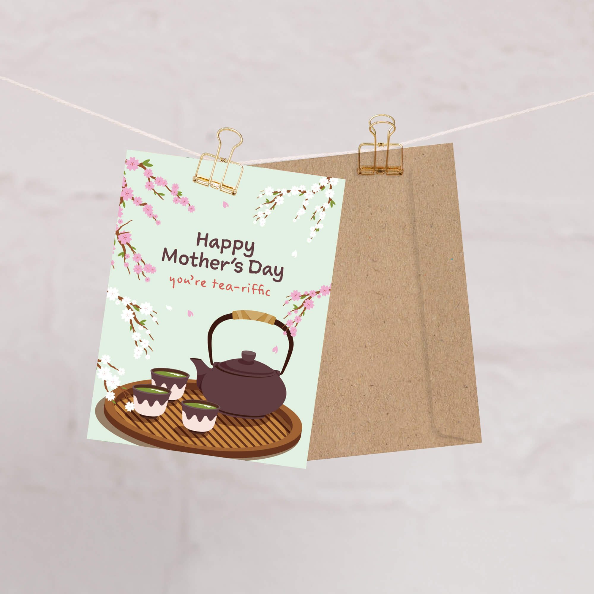 cute Mother's Day card with a brown teapot and cups with green tea and cherry blossom flowers around it with text you're tea-rrific 