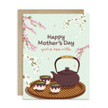 cute Mother's Day card with a brown teapot and cups with green tea and cherry blossom flowers around it with text you're tea-rrific 