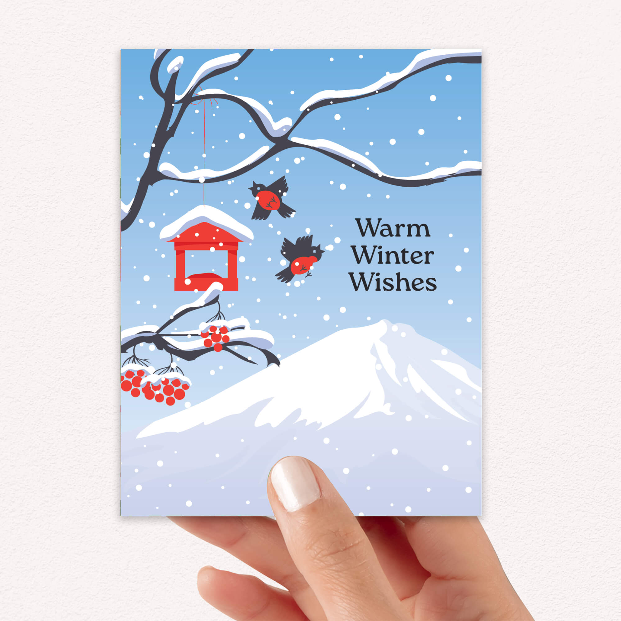 unique japanese christmas card. Snow-covered tree branches with red berries, birds, a red birdhouse, and Mt. Fuji. Text reads “Warm Winter Wishes.”