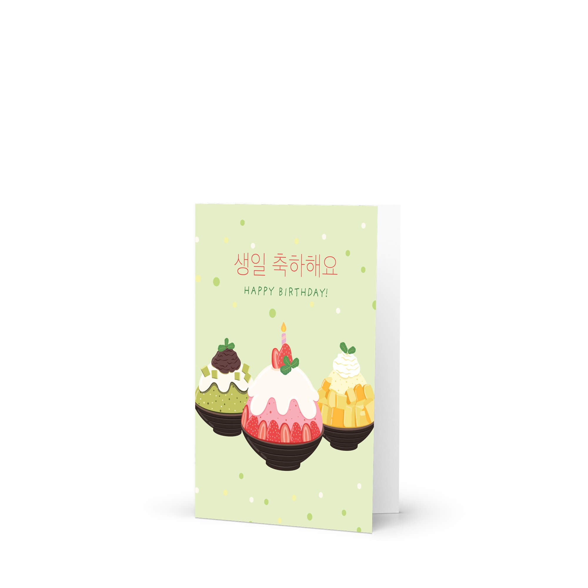 A Korean birthday card with a light green background, featuring three illustrated desserts and the text '대댄대 대날대북도!' and 'HAPPY BIRTHDAY!' in Korean and English. The card is shown standing upright against a clean white background.