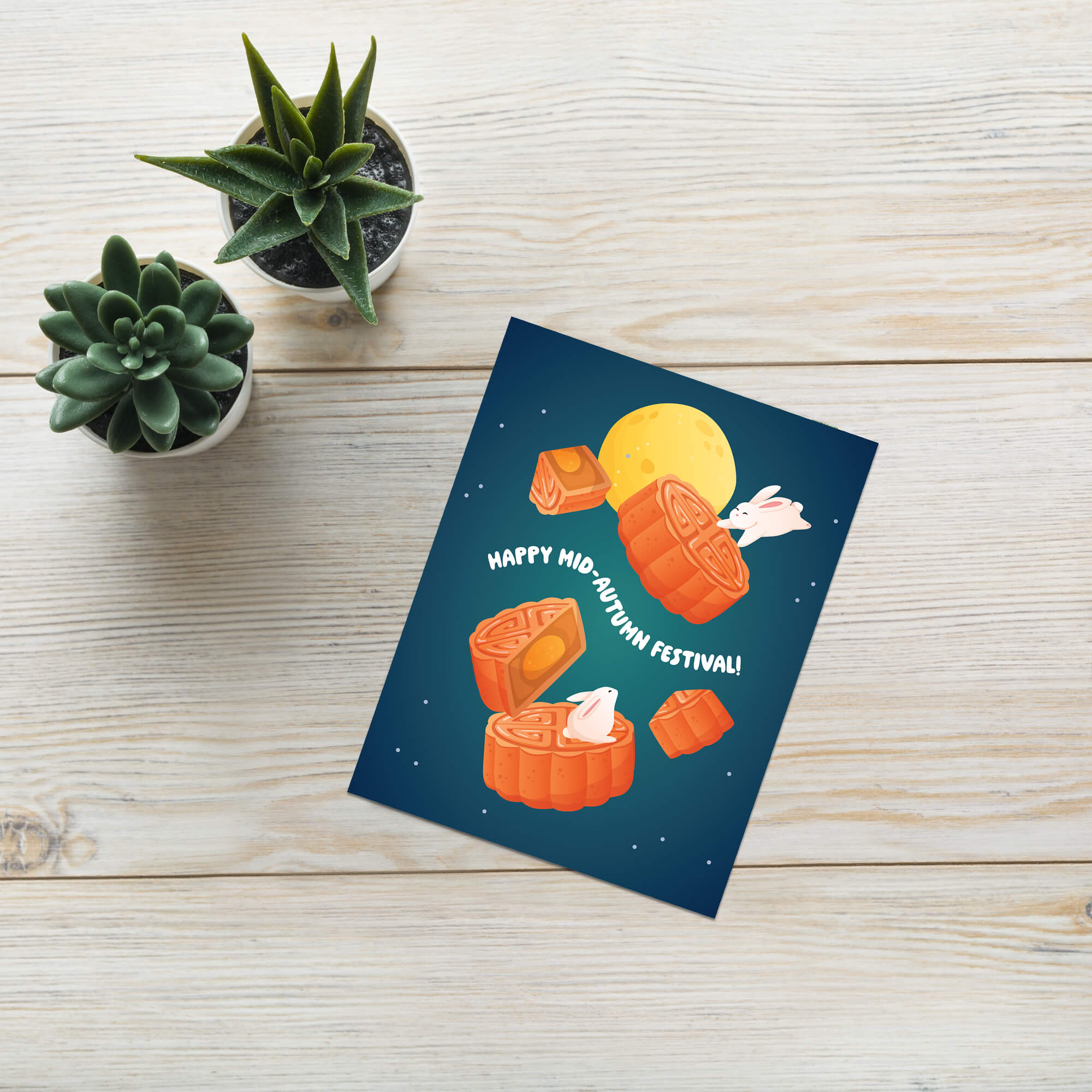 cute kawaii Greeting card with mooncakes and a rabbit illustration on a wooden surface with plants.