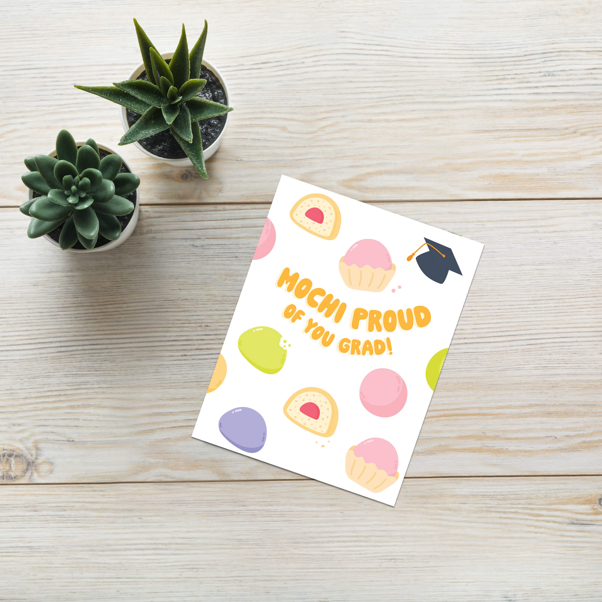 Graduation card with japanese mochi illustrations and text 'Mochi Proud of You Grad!' on a white background.