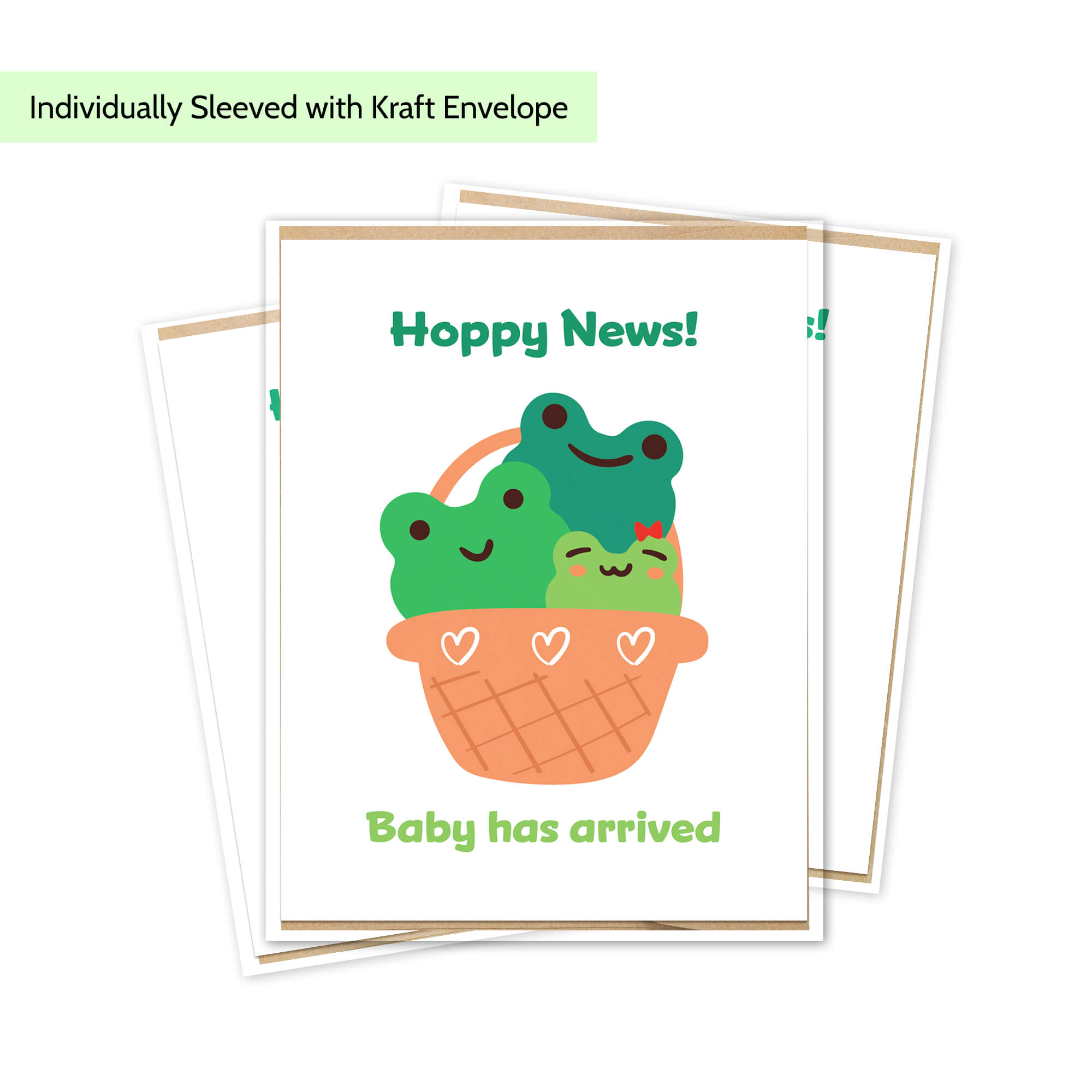 A baby arrival newborn greeting card with a kraft envelope, featuring a cute illustration of three smiling green frogs in an orange basket with the text 'Hoppy News!' and 'Baby has arrived'.