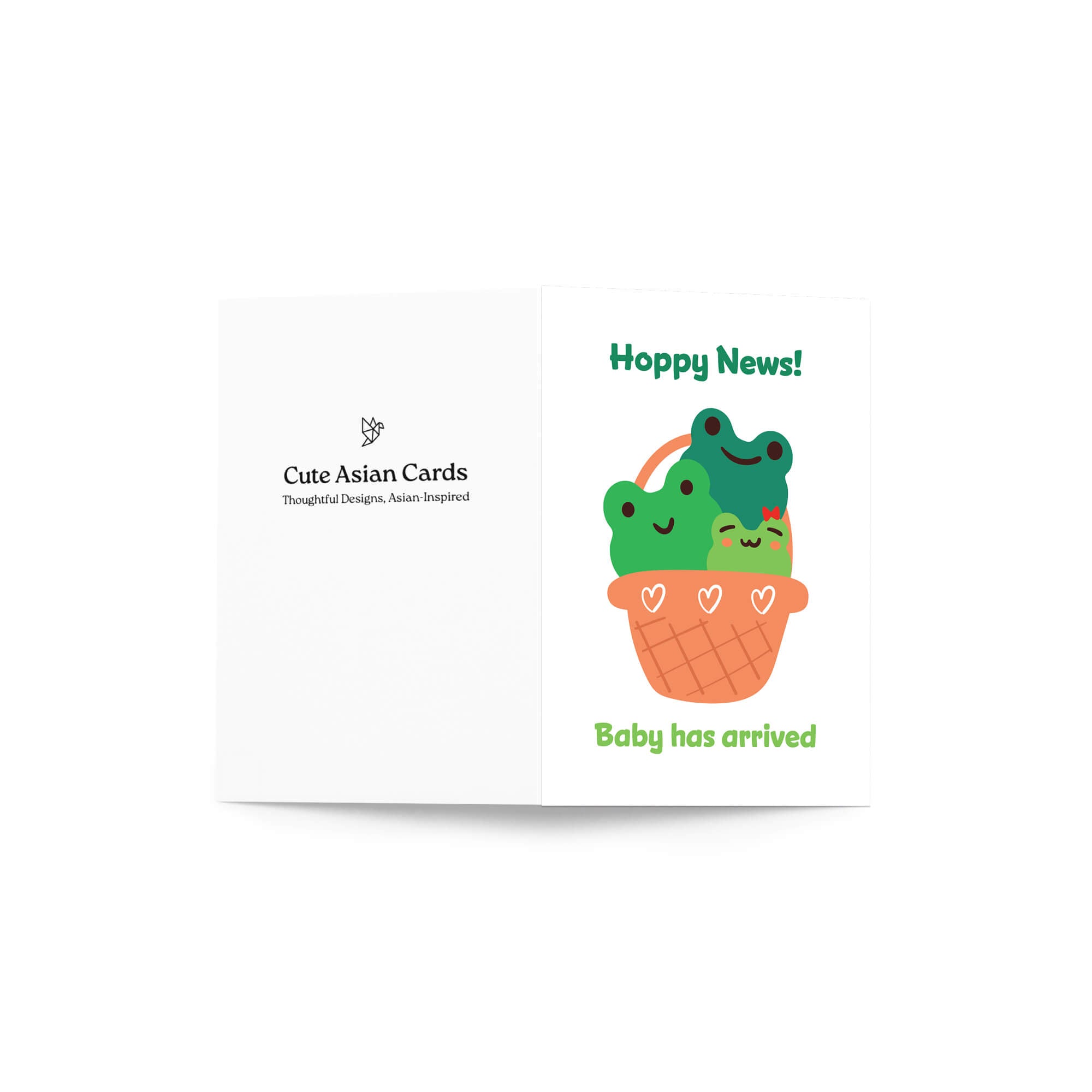 A folded baby shower card shown against a light gray background. The front features the text 'Hoppy News!' above an illustration of two green cartoon frogs hugging in an orange basket, with 'Baby has arrived' written below.