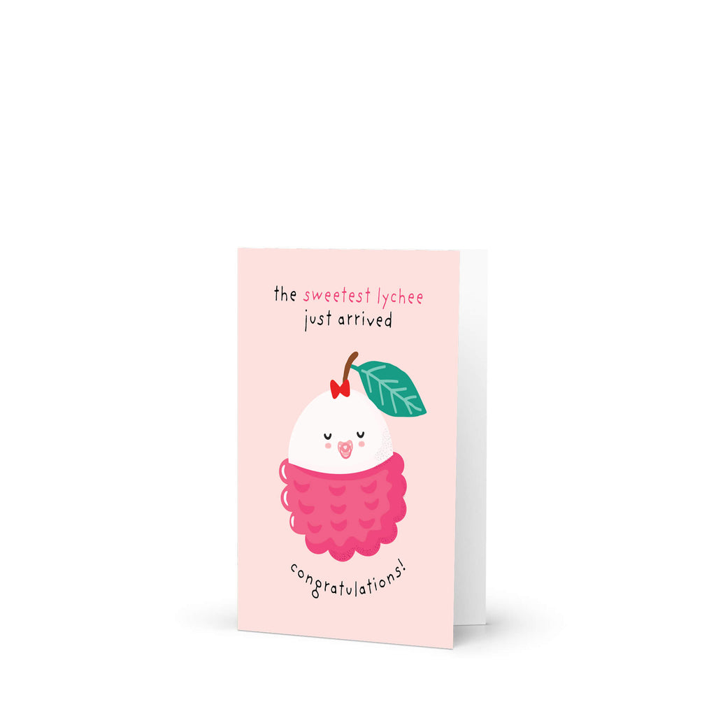 A pink greeting new baby card featuring a cute cartoon lychee illustration with the text 'the sweetest lychee just arrived' and 'congratulations!' on a white background.