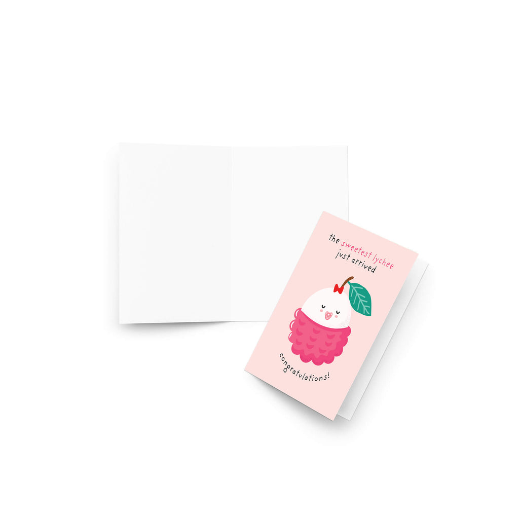 A pink greeting baby shower card with a cute illustration of a cherry cupcake and the text 'the sweetest treat just arrived' and 'congratulations!' shown next to an open white envelope on a white background.