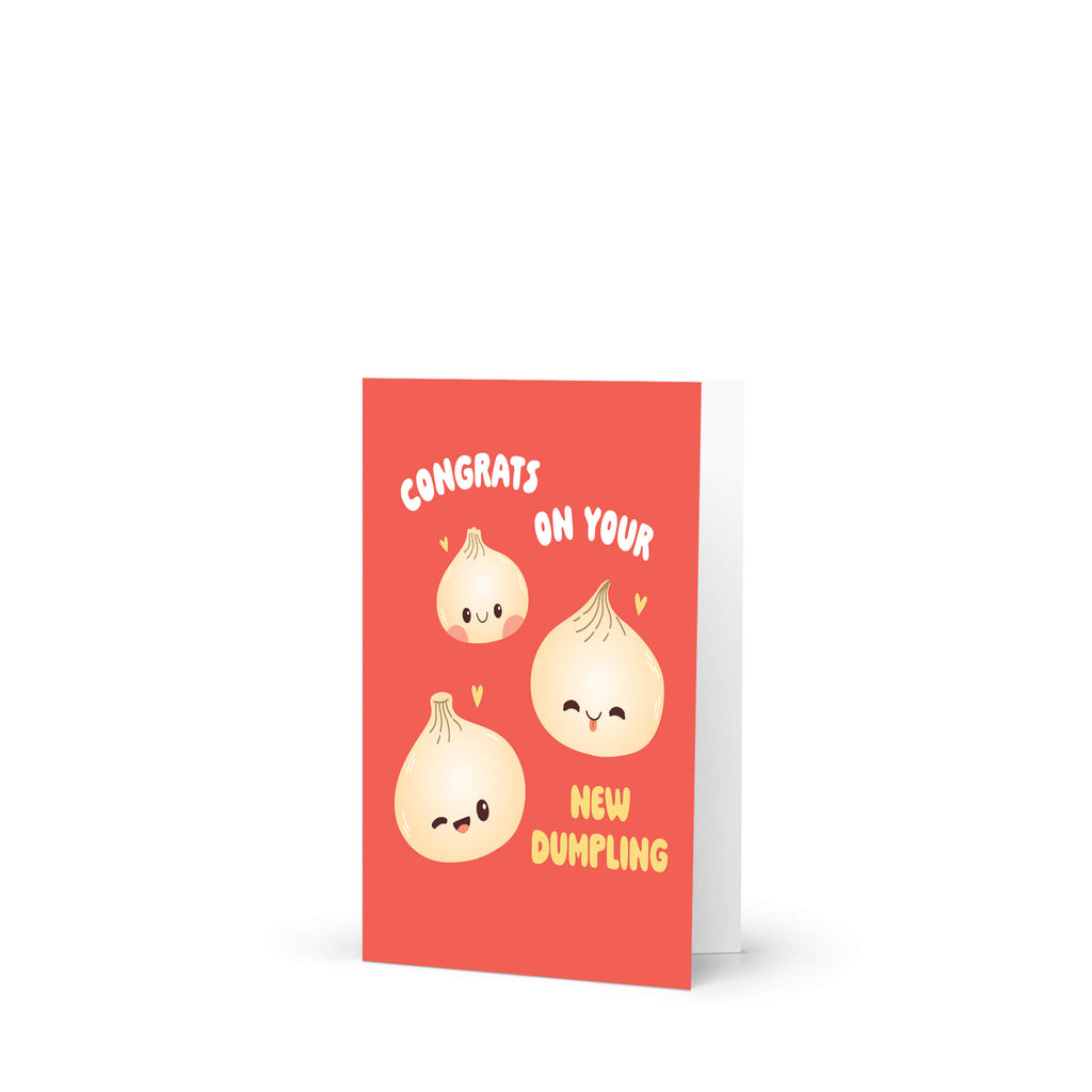 A red greeting card with a white envelope, featuring cute cartoon onions with faces and the text 'CONGRATS ON YOUR NEW DUMPLING'.