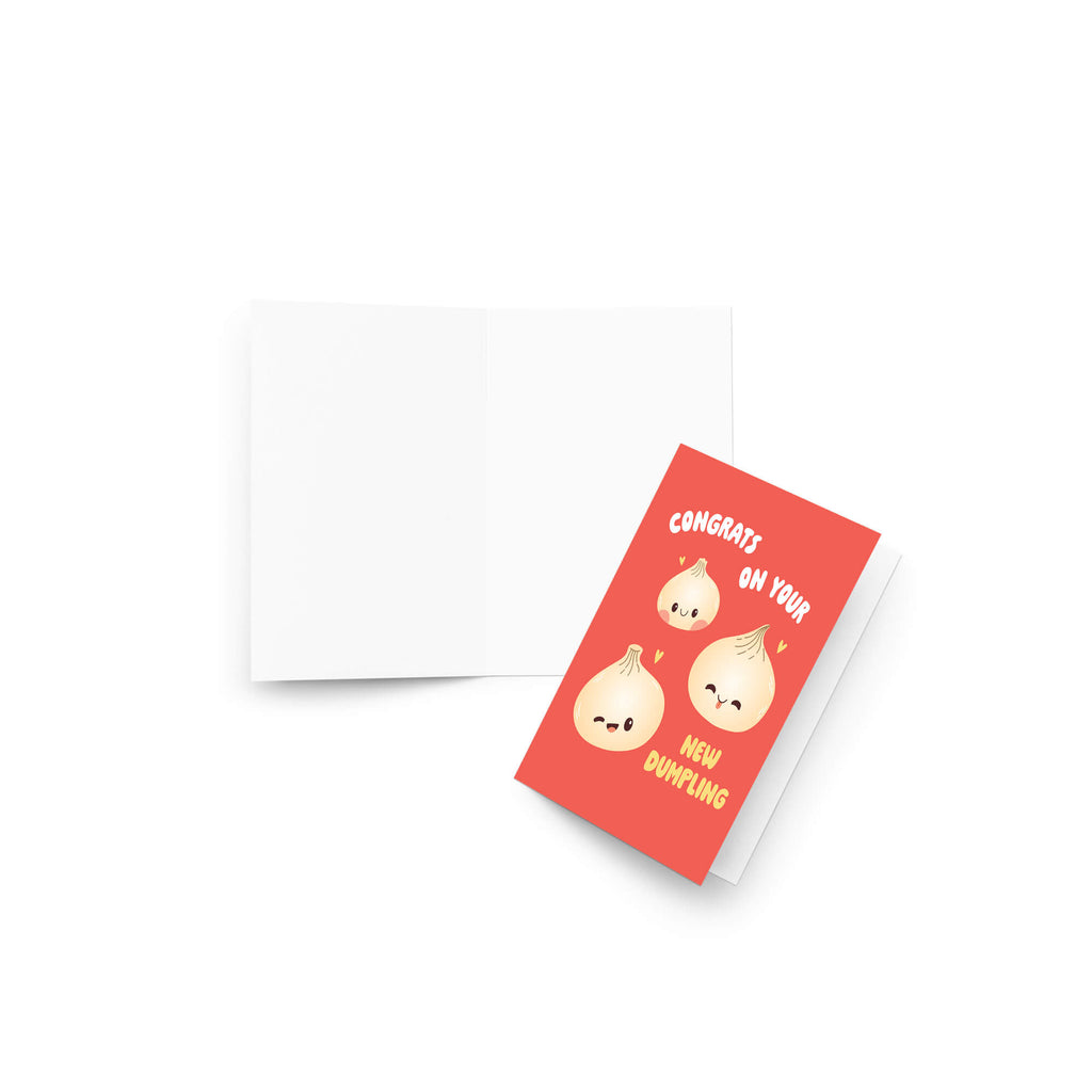 A red greeting card with a white envelope behind it on a white background. The card features three cartoon dumplings with the text 'CONGRATS ON YOUR NEW DUMPLING'.