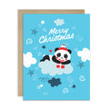 cute christmas card with A panda wearing a Santa hat floats on a cloud holding a red gift box. Surrounded by stars and snowflakes. Text reads “Merry Christmas.”