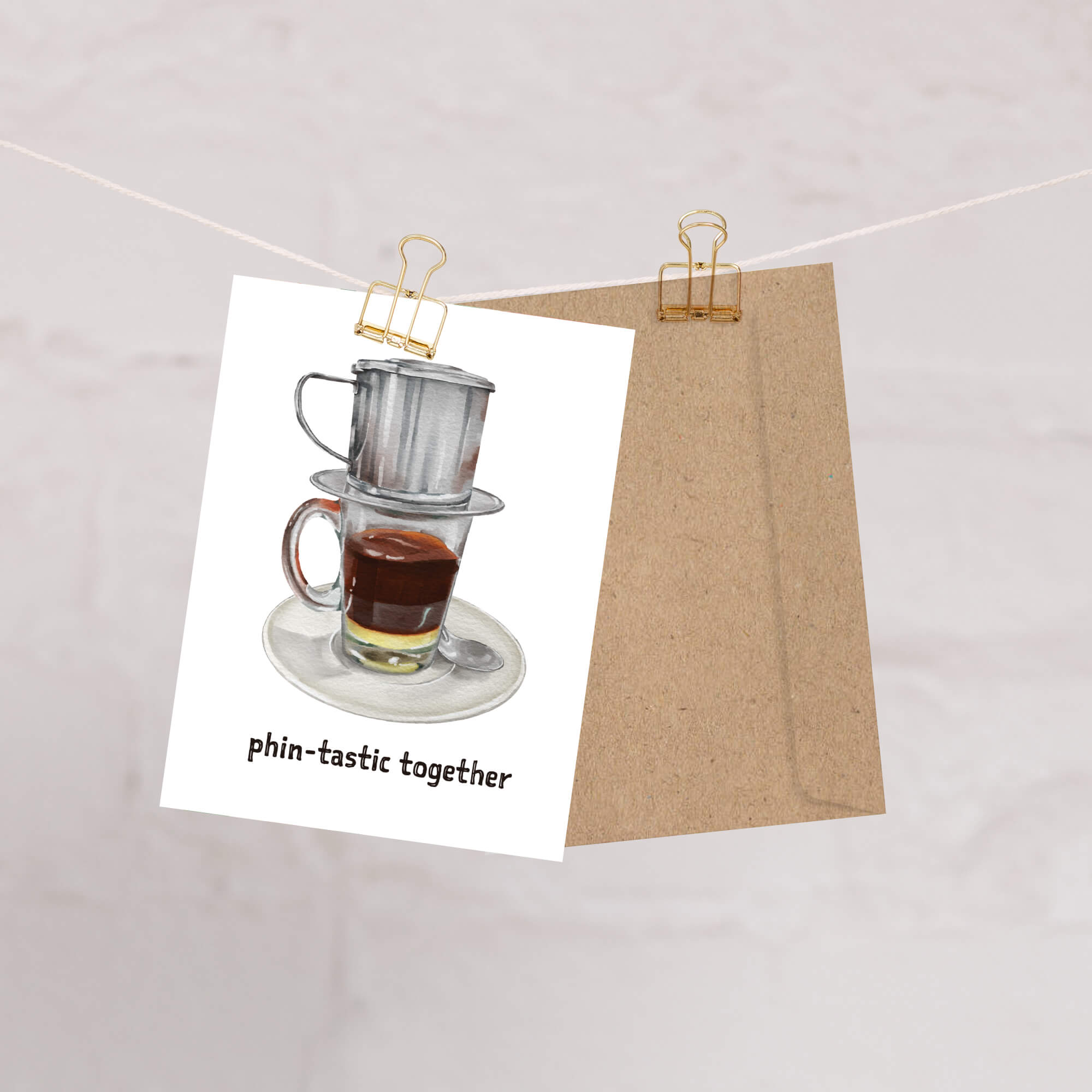 Card with a coffee-themed design featuring a coffee filter and cup, held up by a string with clips.