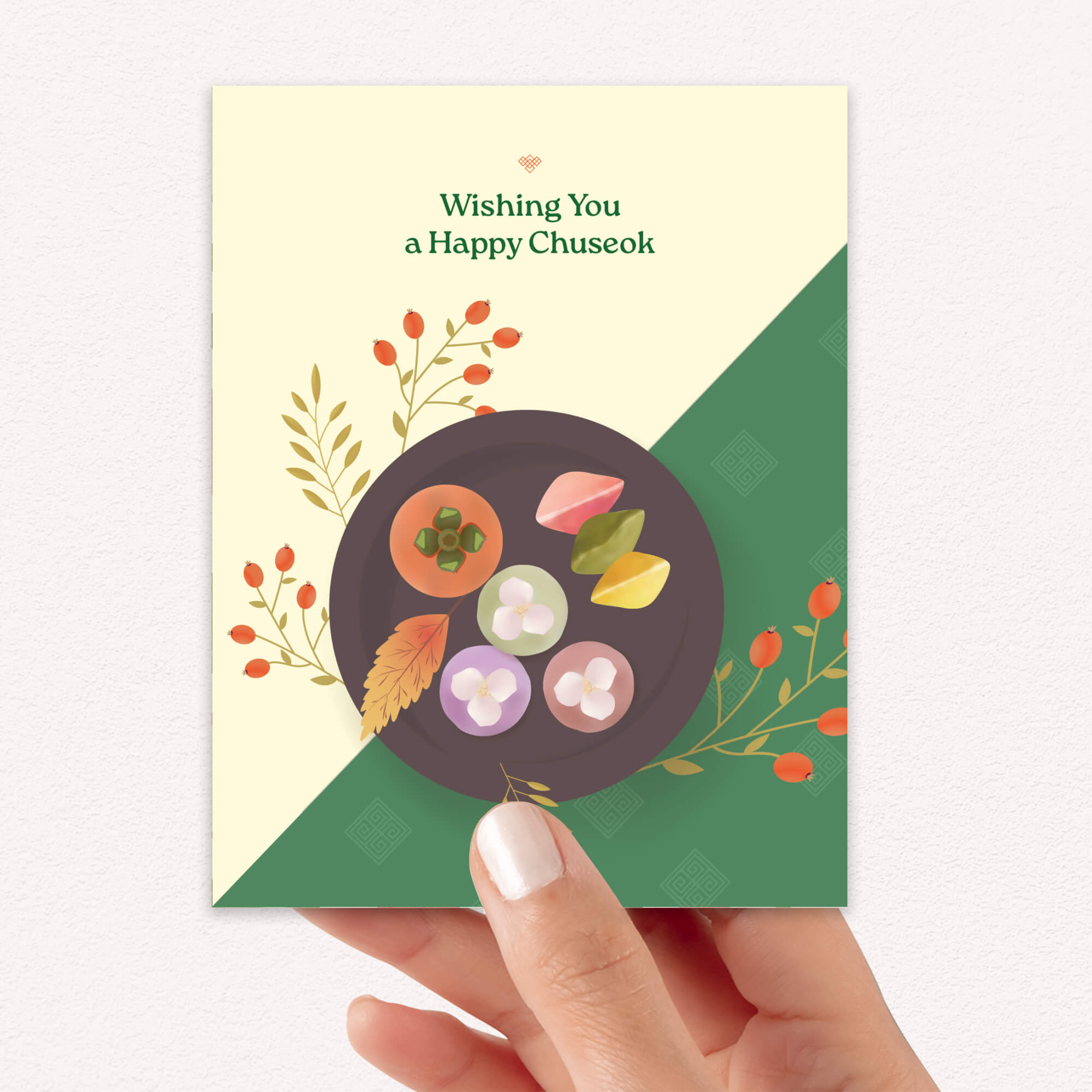 korean Greeting card with a plate of traditional Korean dishes Persimmon, Songpyeon & Hangwa for mid autumn festival  on a green and beige background.