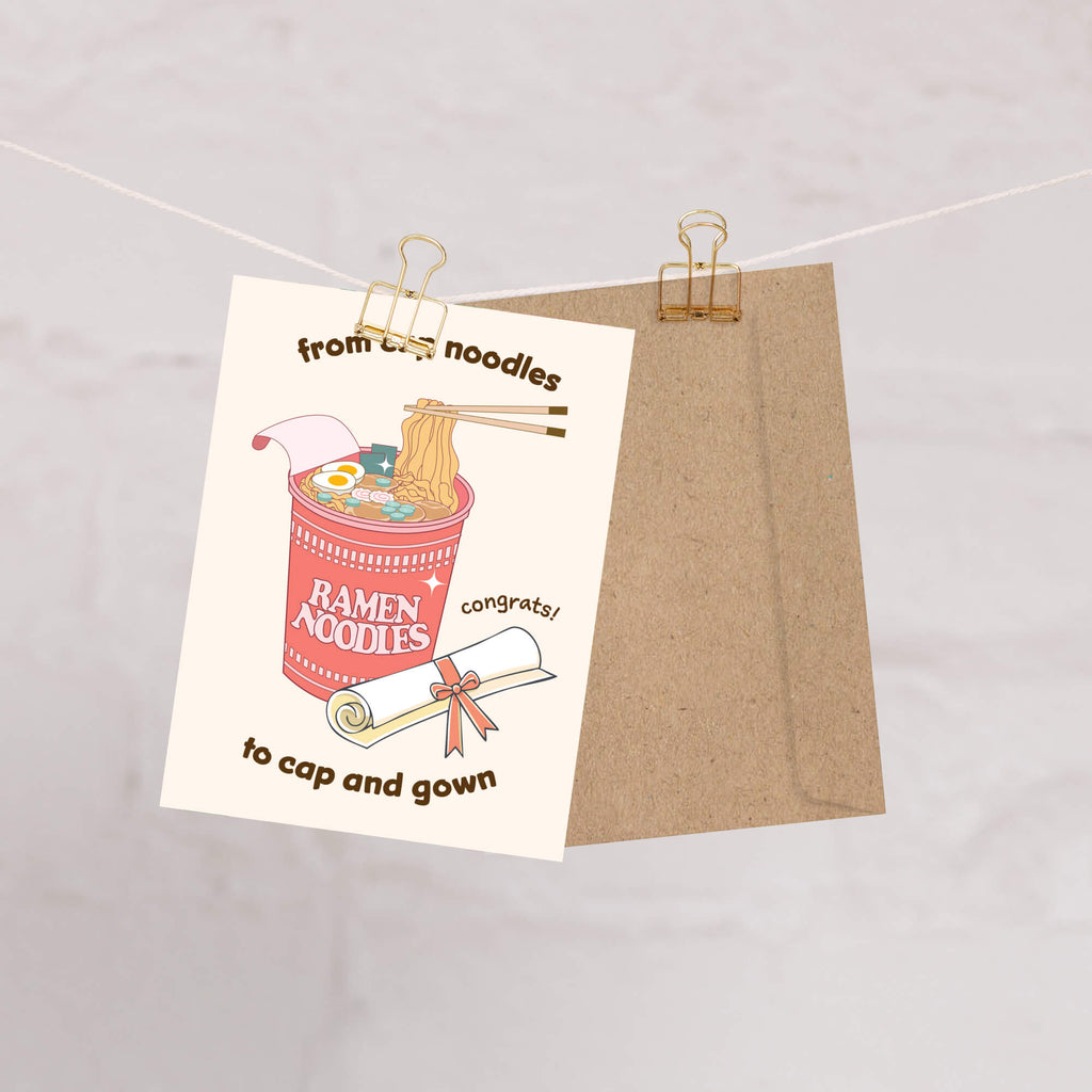 care graduation card with a cup of ramen noodles and text 'From cup noodles to cap and gown' on a beige background.