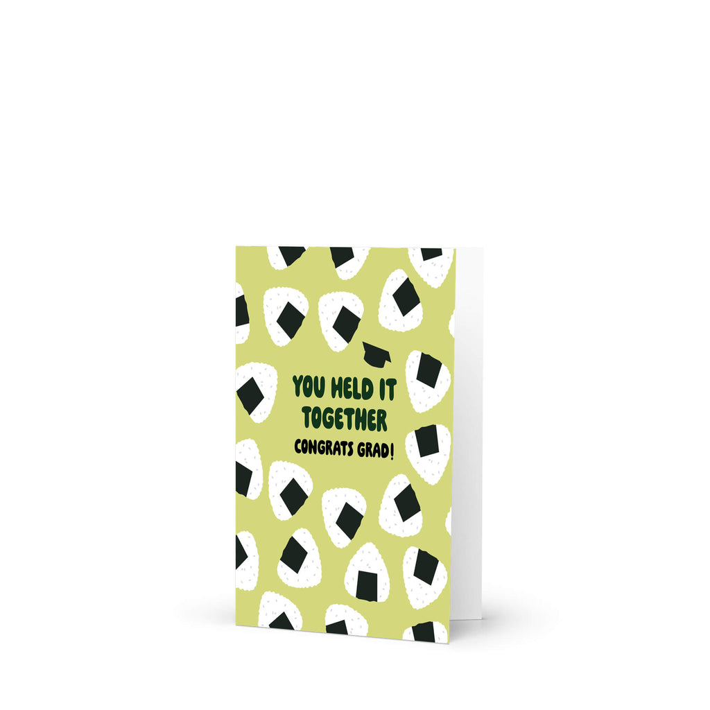 Graduation card with japanese onigiri rice ball pattern and text 'You held it together. Congrats grad!' on a white background.