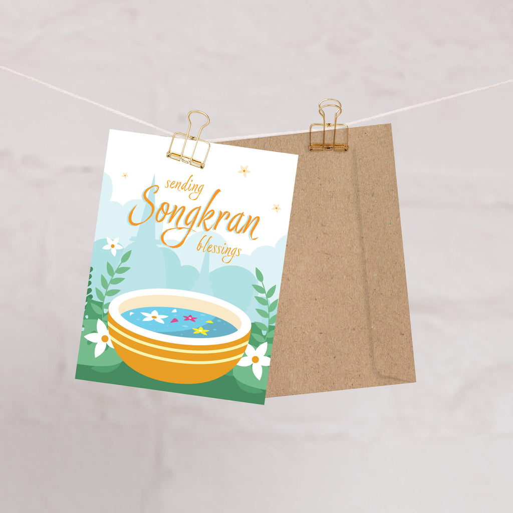 thai new year card with a bowl of spa water and flowers, featuring 'sending Songkran blessings' text.