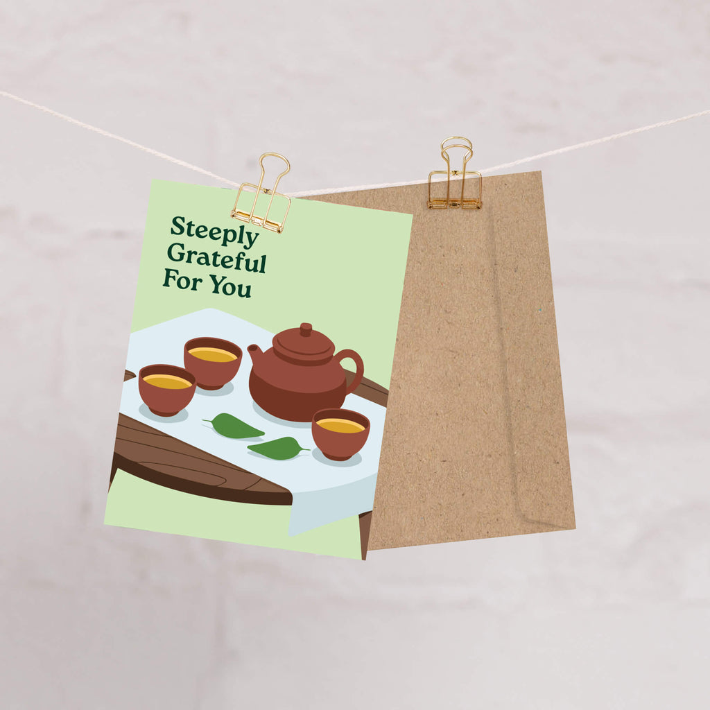 Greeting card with tea illustration and 'Steeply Grateful For You' text, attached to a string with a paper clip.