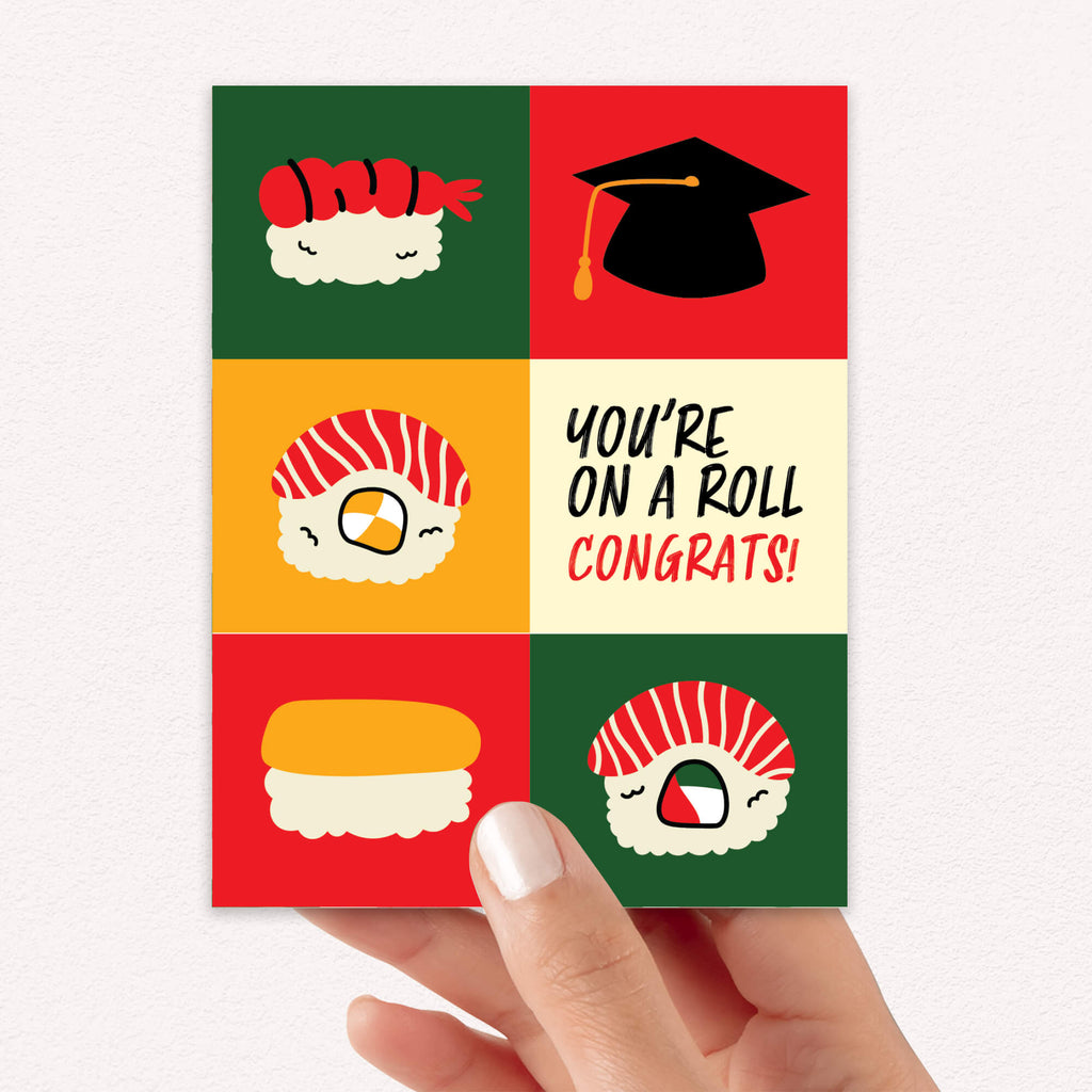 graduation card with sushi illustrations and a graduation cap, featuring the text 'You're on a roll congrats!'