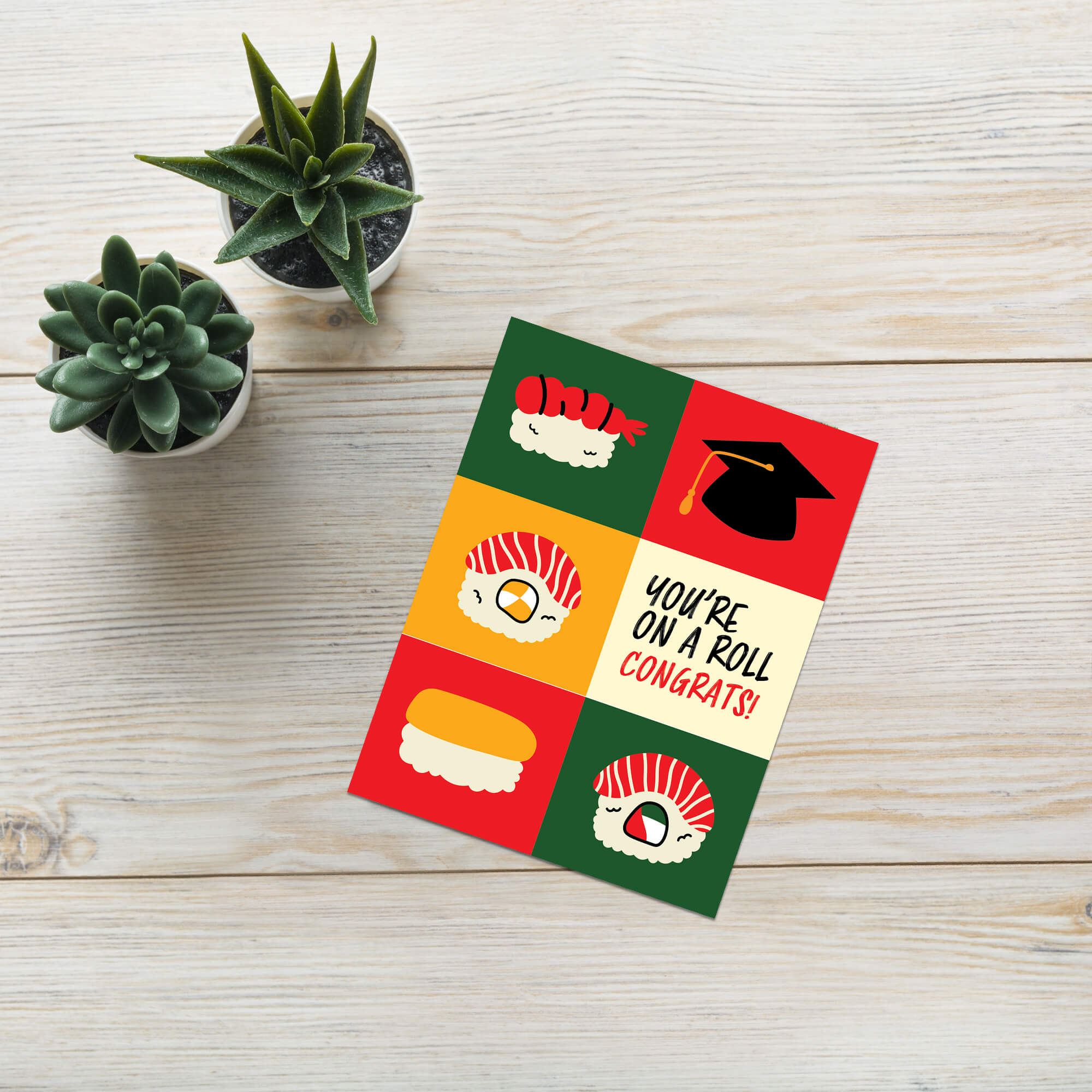 graduation card with sushi illustrations and a graduation cap, featuring the text 'You're on a roll congrats!'