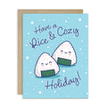 unique christmas card with Two smiling onigiri (japanese rice ball snacks) on snowy blue with text “Have a Rice & Cozy Holiday.”