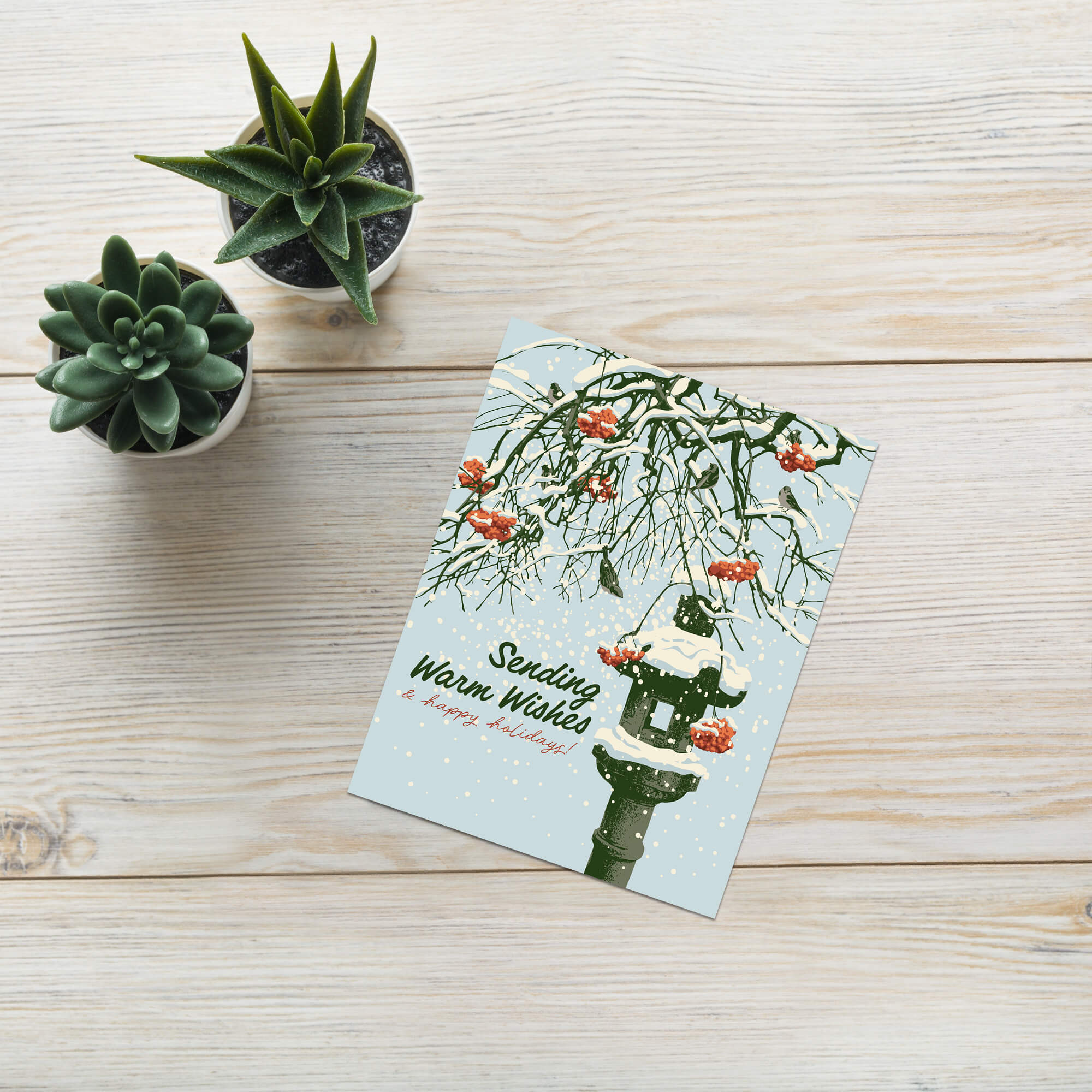 Greeting card with winter scene, snow-covered branches, Snowy ishi-dōrō stone lantern with red berries, and text 'Sending Warm Wishes & happy holidays!'.