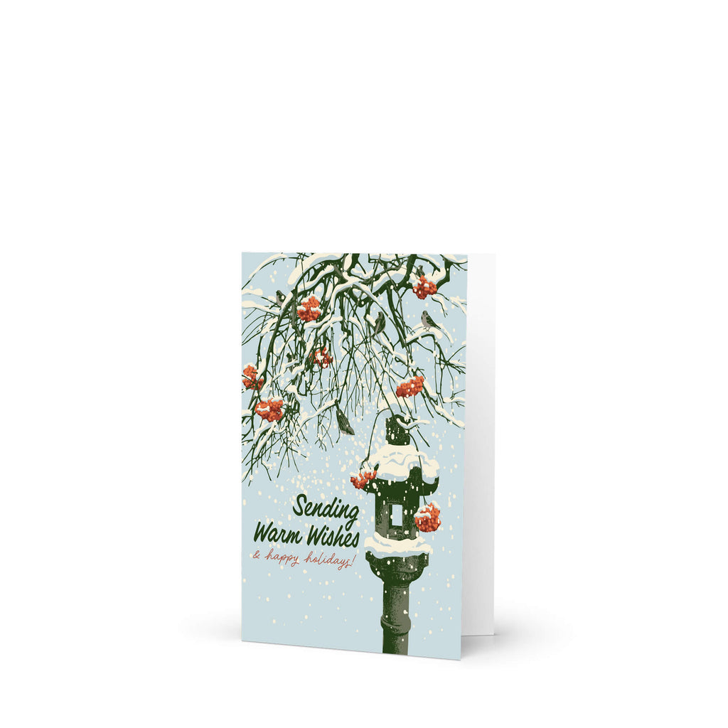 Greeting card with winter scene, snow-covered branches, Snowy ishi-dōrō stone lantern with red berries, and text 'Sending Warm Wishes & happy holidays!'.