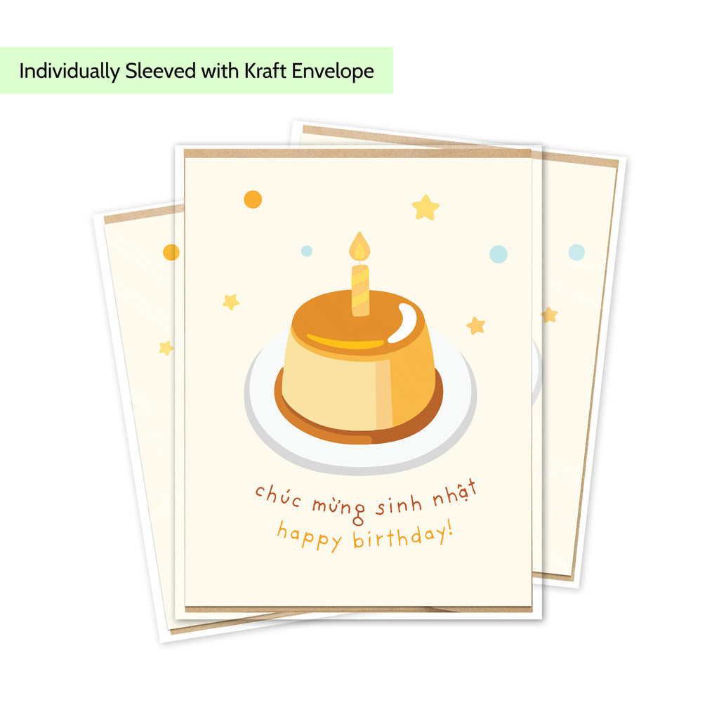A stack of Vietnamese bday cards with a cream-colored background, featuring an illustration of a dessert cake with a candle and the Vietnamese text 'chúc mừng sinh nhật happy birthday!'. A light green banner at the top reads 'Individually Sleeved with Kraft Envelope'.