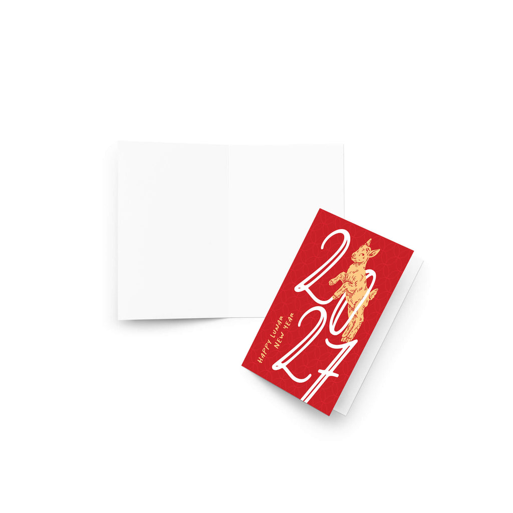 A year of the ram card with white '2027' numerals and a gold cat illustration, shown with an open blank white card behind it on a light gray background.
