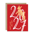 A red chinese new Year greeting card with a kraft envelope behind it. The card features a gold goat illustration and large white '2027' numerals, with 'HAPPY LUNAR NEW YEAR' printed vertically on the left.