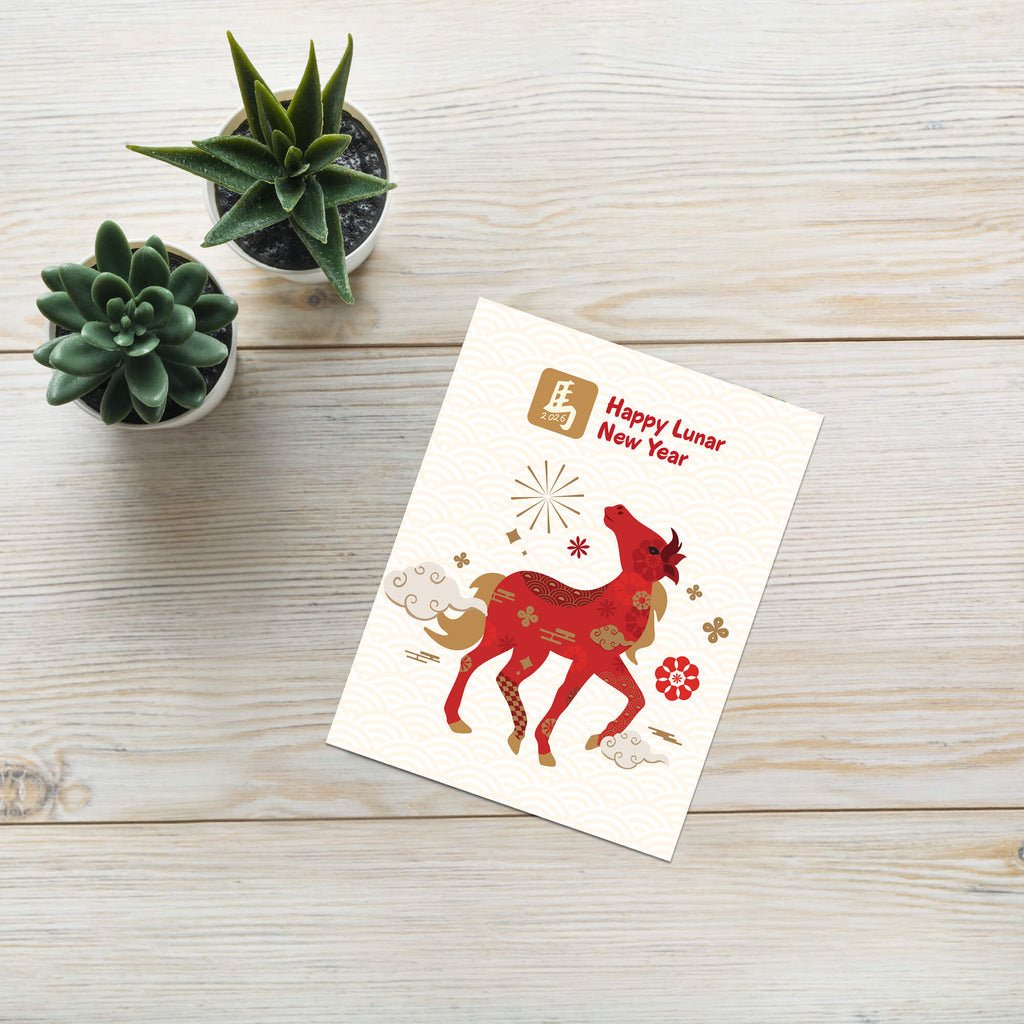 Lunar New Year card with a red deer illustration on a wooden surface with small plants.